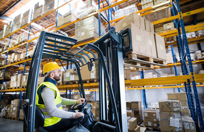 forklift-operator-stocking-shelves-in-warehouse